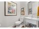 Bathroom with toilet, modern sink, and stylish wall art, showcasing the home's attention to detail at 291 River Rd, Oak Hill, FL 32759