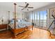Bedroom with a four-poster bed, hardwood floors, ceiling fan, and sliding glass doors with water view at 291 River Rd, Oak Hill, FL 32759