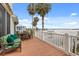 Deck overlooking the water, featuring comfortable seating and idyllic palm tree views at 291 River Rd, Oak Hill, FL 32759