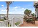 Waterfront deck with dock views, a dining area with outdoor seating, and lush green foliage at 291 River Rd, Oak Hill, FL 32759