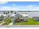Aerial view of charming home on the river with lush green lawn and mature palm trees at 291 River Rd, Oak Hill, FL 32759
