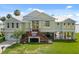 Inviting waterfront home with a lush lawn, yellow door, and elevated architecture at 291 River Rd, Oak Hill, FL 32759