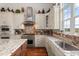 Bright kitchen featuring granite countertops, custom cabinetry, stainless steel appliances and hardwood flooring at 291 River Rd, Oak Hill, FL 32759