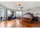 Waterfront bedroom featuring hardwood floors, ceiling fan, and a private balcony with water views at 291 River Rd, Oak Hill, FL 32759