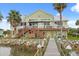 Back of waterfront home showing a wooden deck, stairs to the water, and tropical foliage at 291 River Rd, Oak Hill, FL 32759