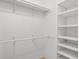 A well-organized walk-in closet features shelving and rods for optimal storage solutions in a neutral color palette at 3055 Dellcrest Pl, Lake Mary, FL 32746