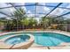 A beautiful screened-in pool and spa area surrounded by lush landscaping and a wooden fence, perfect for relaxation at 3055 Dellcrest Pl, Lake Mary, FL 32746