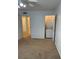 View of bedroom with tan carpet and a stackable washer and dryer in an open closet at 315 Wymore Rd # 104, Altamonte Springs, FL 32714