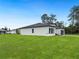 View of the home's side with well-kept lawn, showcasing the property's spacious yard at 3420 Sw 130Th Lane Rd, Ocala, FL 34473