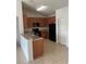 Well-equipped kitchen with wooden cabinetry, a breakfast bar, and modern black appliances at 3651 Sail Harbor Dr, Kissimmee, FL 34746