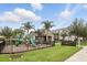 Community playground with slides, palm trees, and lush landscaping on a sunny day at 439 Windmill Palm Cir, Altamonte Springs, FL 32701