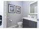 Stylish half bathroom featuring a gray vanity, modern sink, decorative mirror, and tiled flooring at 4414 Le Reve Ct, Kissimmee, FL 34746