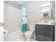 Bright bathroom with white tiled shower-tub, toilet, gray vanity and illuminated mirror at 4414 Le Reve Ct, Kissimmee, FL 34746