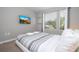 This bedroom features a mounted tv, a window view, and light gray decor at 4414 Le Reve Ct, Kissimmee, FL 34746