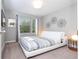 This bedroom has white trim, a window view, and unique geometric artwork at 4414 Le Reve Ct, Kissimmee, FL 34746