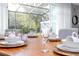 Dining room with a wooden table set for a meal, looking out to the screened-in patio at 4414 Le Reve Ct, Kissimmee, FL 34746