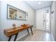 Bright entryway with light tile flooring, a stylish wood console table with metal legs, and a decorative mirror at 4414 Le Reve Ct, Kissimmee, FL 34746