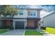 Modern two-story home featuring a gray color scheme, a well-maintained lawn, and a paver driveway leading to a one-car garage at 4414 Le Reve Ct, Kissimmee, FL 34746
