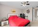 This bedroom features neutral walls, a ceiling fan, and is decorated with posters and a red bedspread at 479 Harbor Winds Ct, Winter Springs, FL 32708