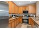 The kitchen boasts modern stainless appliances, granite countertops, and ample wood cabinetry for storage at 479 Harbor Winds Ct, Winter Springs, FL 32708