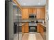Well-lit kitchen with stainless steel appliances, wooden cabinets, and granite countertops provides an efficient cooking space at 479 Harbor Winds Ct, Winter Springs, FL 32708