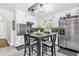Eat-in kitchen with stainless steel appliances, white cabinets, and a cozy dining table at 512 Dixson St, Orange City, FL 32763