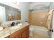 Modern bathroom features granite countertops, vanity, and tub with tiled walls at 5165 Mystic Point Ct, Orlando, FL 32812