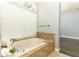 Well-lit bathroom featuring a jetted tub beneath a window, perfect for relaxation at 5165 Mystic Point Ct, Orlando, FL 32812