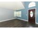 Light-filled living area showcasing new wood flooring, freshly painted walls, and high ceilings and a decorative front door at 5165 Mystic Point Ct, Orlando, FL 32812