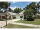 A suburban home with a lush green lawn, mature trees, a two-car garage, and a charming exterior design at 5165 Mystic Point Ct, Orlando, FL 32812