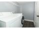 Clean laundry room features a washer, dryer, wood look floors, and storage shelving at 5165 Mystic Point Ct, Orlando, FL 32812