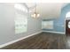 Expansive open-concept living area with new wood floors, fresh paint, and a chandelier adding a touch of elegance at 5165 Mystic Point Ct, Orlando, FL 32812
