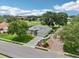 Sprawling golf course home showcasing meticulous landscaping, mature trees, and a large driveway leading to an attached garage at 5453 Grove Mnr, Lady Lake, FL 32159