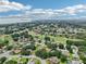 Aerial view showcasing a community with a golf course and a lake in the distance at 5453 Grove Mnr, Lady Lake, FL 32159