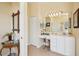 Cozy bathroom with a vanity area, neutral tiling, and a decorative mirror in a well-lit setting at 5453 Grove Mnr, Lady Lake, FL 32159