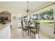 Bright dining area featuring a glass table, modern chairs, and a view of the screened-in lanai at 5453 Grove Mnr, Lady Lake, FL 32159