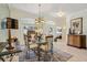 Elegant dining room featuring glass-top table, chandelier lighting, and arched doorways at 5453 Grove Mnr, Lady Lake, FL 32159