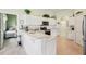 Bright kitchen featuring white cabinets, modern appliances, and an adjacent breakfast bar with views into the adjacent bedroom at 5453 Grove Mnr, Lady Lake, FL 32159