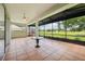 The lanai showcases tile flooring, a ceiling fan, and serene views of the golf course at 5453 Grove Mnr, Lady Lake, FL 32159