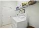 Functional laundry room with a washer, dryer, shelving, and a clean white door for seamless utility at 5453 Grove Mnr, Lady Lake, FL 32159