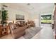 Comfortable living room featuring leather furniture, a ceiling fan, and sliding glass doors leading to the lanai at 5453 Grove Mnr, Lady Lake, FL 32159