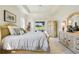 Spacious bedroom with a tray ceiling, decorative furniture, and an expansive view of the outdoors at 5453 Grove Mnr, Lady Lake, FL 32159