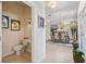 Hallway view including a powder room and a dining room with large mirror reflecting the chandelier at 5453 Grove Mnr, Lady Lake, FL 32159