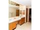 Bathroom featuring a double sink vanity with cabinets, a large mirror, and a doorway at 596 Starstone Dr, Lake Mary, FL 32746