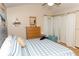 The bright bedroom has a ceiling fan and a wooden dresser beneath a coastal wall hanging at 596 Starstone Dr, Lake Mary, FL 32746