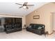 A spacious living room features tile floors, a ceiling fan, and comfortable leather sofas at 596 Starstone Dr, Lake Mary, FL 32746