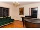 Elegant living room featuring hardwood floors, a classic sofa, and a grand piano, perfect for relaxation and entertainment at 596 Starstone Dr, Lake Mary, FL 32746