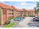 Exterior of a multi-story condominium building featuring a red tile roof, multiple balconies, and ample parking at 6337 Parc Corniche Dr # 2312, Orlando, FL 32821