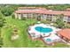 Aerial view of the community pool, playground, green space, and condominium building at 6337 Parc Corniche Dr # 2312, Orlando, FL 32821
