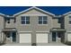 Townhouse exterior with gray siding, white trim, dual garages and blue front doors at 6615 Leo Ln, St Cloud, FL 34773